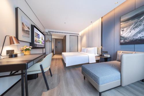 a hotel room with a bed and a desk and a desk sidx sidx sidx sidx at Atour Hotel Guangzhou Zhujiang New Town Taikoo Hui in Guangzhou