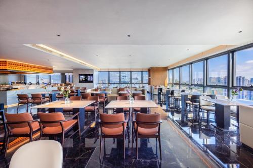 a restaurant with tables and chairs and large windows at Atour S Hotel Shenzhen Luohu Shuibei in Shenzhen