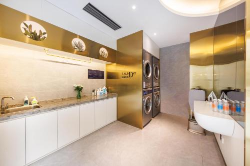 a bathroom with a sink and a washer and dryer at Atour Light Hotel Zhuguang Road Hongqiao National Exhibition and Convention Center in Shanghai