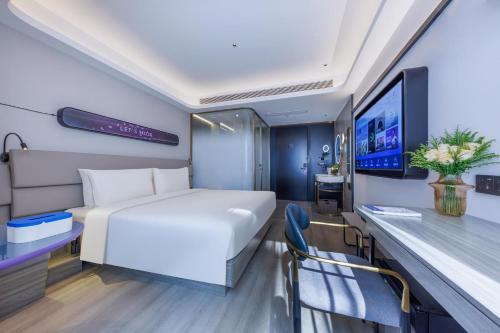 um quarto de hotel com uma cama e uma televisão em Atour Light Hotel Shanghai Lujiazui Financial Center em Xangai