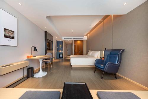 ein Hotelzimmer mit einem Bett und einem Schreibtisch in der Unterkunft Atour Hotel Foshan Shunde Happy Coast in Shunde