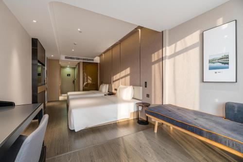 a hotel room with a bed and a couch at Atour Hotel Hangzhou Qianjiang Century City International Expo Center in Xiaoshan