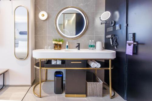 La salle de bains est pourvue d'un lavabo et d'un miroir. dans l'établissement Atour Light Hotel Shanghai Lujiazui Financial Center, à Shanghai