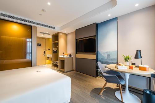 a hotel room with a desk and a table at Atour Hotel Hangzhou Huanglong Wanke Xueyuan Road in Hangzhou