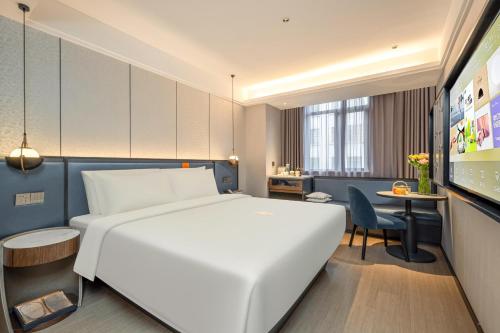 a hotel room with a white bed and a desk at Atour X Hotel Shanghai Bund East Nanjing Road Pedestrian Street in Shanghai