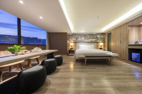 een slaapkamer met een bed en een tafel en stoelen bij Atour Hotel Guangzhou Avenue Tianhe Sports Center in Guangzhou
