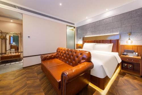 a bedroom with a bed and a leather couch at Atour X Hotel Beijing Daxing Airport Wildlife Park in Daxing