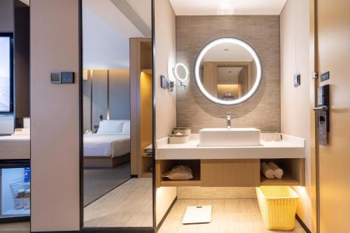 a bathroom with a sink and a mirror at Atour Hotel Zhongshan Nantou Haiya Colorful City in Zhongshan