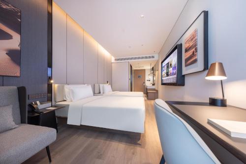 una camera d'albergo con letto bianco e scrivania di Atour Hotel Beijing Beiqing Road Yongfeng Science and Technology Park a Pechino