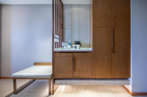 bagno con panca e lavandino di Atour X Hotel Beijing Yonghe Temple Hepingli a Pechino