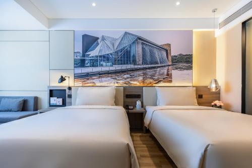 duas camas num quarto de hotel com um quadro na parede em Atour Hotel Shenzhen Luohu Diwang em Shenzhen