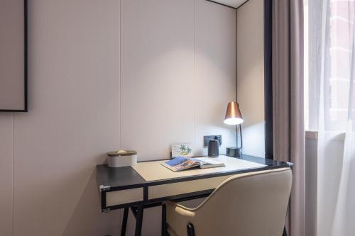 a desk with a chair and a lamp on it at Atour X Hotel Shenzhen Luohu Sungang Baoneng Center in Shenzhen
