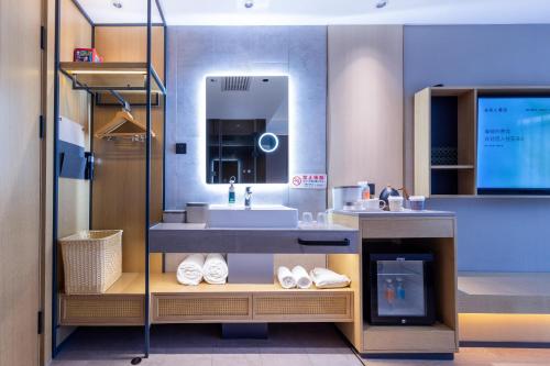 uma casa de banho com um lavatório e um espelho em Atour X Hotel Beijing Majiabao Subway Station em Pequim