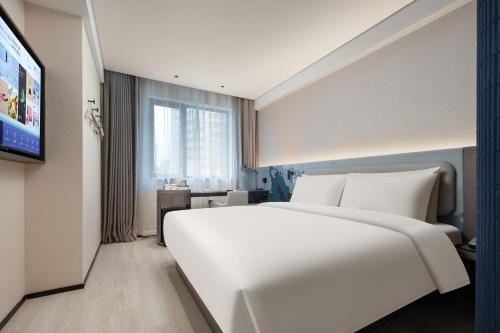 1 cama blanca grande en una habitación de hotel en Atour Light Hotel Hangzhou West Lake Huanshan Road en Hangzhou