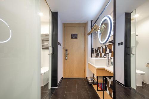 uma casa de banho com um lavatório e um WC em Atour X Hotel Shanghai Xujiahui Sports Center em Xangai