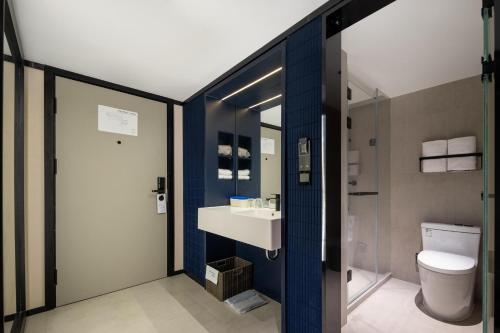 La salle de bains est pourvue d'un lavabo et de toilettes. dans l'établissement Atour Light Hotel Hangzhou West Lake Wulin Plaza North Huancheng Road, à Hangzhou