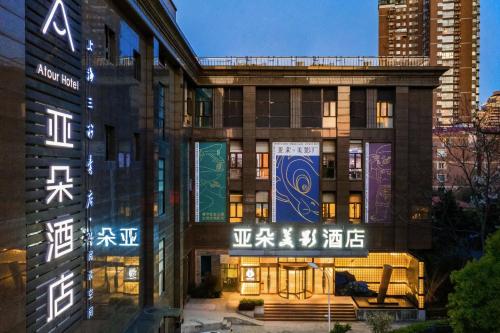 a building with neon signs on the side of it at Atour Hotel Xujiahui Meiying in Shanghai