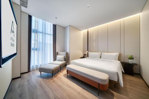 ein Hotelzimmer mit einem Bett und einem TV in der Unterkunft Atour Hotel Hangzhou Jiubao Passenger Transport Center Jiutian Huanbei in Hangzhou