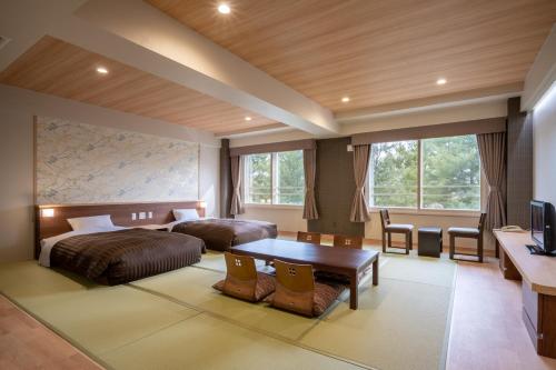 Habitación de hotel con 2 camas y mesa en Hotel Daiheigen, en Otofuke