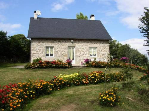 a stone house with flowers in front of it at Gîte de France Chez dédé et léa 3 épis - Gîte de France 6 personnes MAE-9414 in Sarroux