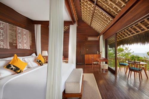 a bedroom with a bed and a table and chairs at Lelewatu Resort Sumba in Watukarere