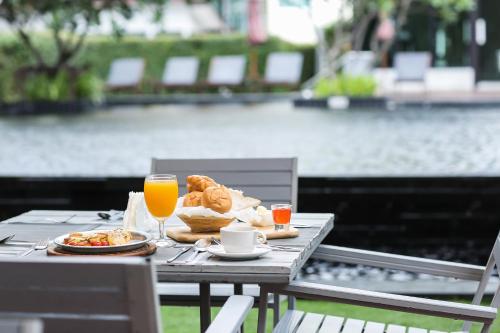 a table with breakfast food and orange juice on it at Fifth Pattaya Jomtien By Shiwalai Int in Jomtien Beach