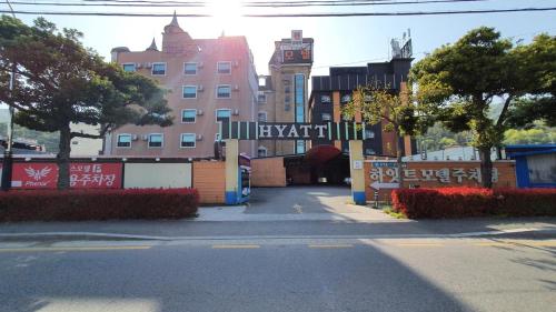 una calle de la ciudad con un edificio con una torre de reloj en Hyatt Motel en Suncheon