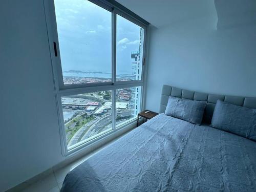 a bedroom with a bed and a large window at Amazing Ocean View 1bed Suite in Panama City