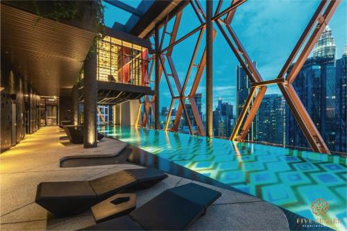 Una piscina en un edificio con vistas al horizonte de la ciudad. en Scarletz Suites Kuala Lumpur, Five Senses, en Kuala Lumpur