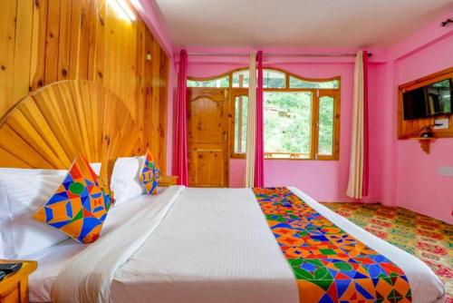 a bedroom with a large bed in a pink room at Forest Retreat in Manāli