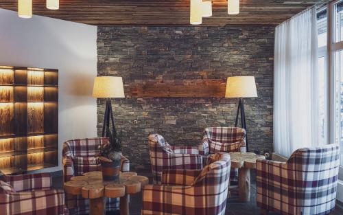 a living room with chairs and a table and a brick wall at Mountain Plaza Hotel in Davos