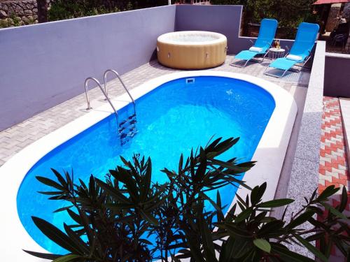 une piscine avec des chaises bleues et une piscine dans l'établissement Gorgeous homes with swimming pool jacuzzi and a magnificent sea view, à Dramalj