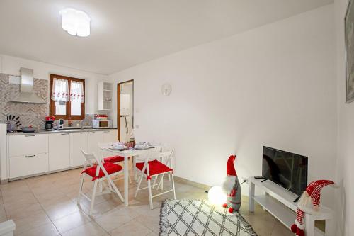 uma cozinha e sala de estar com uma mesa e uma televisão em Lami Apartment Intra Center - Happy Rentals em Verbania