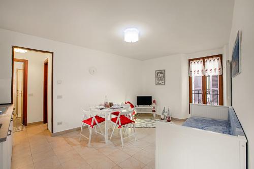 uma sala de estar com uma mesa e cadeiras vermelhas em Lami Apartment Intra Center - Happy Rentals em Verbania