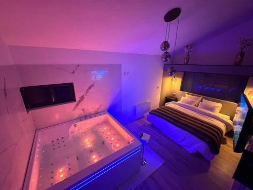 a bedroom with a bed and a tub with lights at L’Autre Nuit 