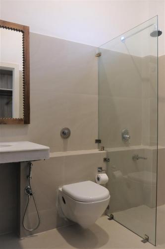 a bathroom with a toilet and a glass shower at Heirloom Guesthouse in Dimāpur