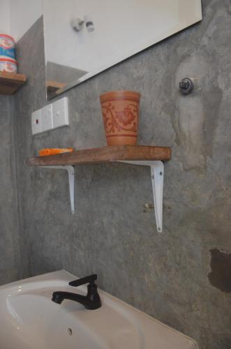 a shelf on the wall above a bathroom sink at The Stables Oceanfront Hotel Midigama in Midigama