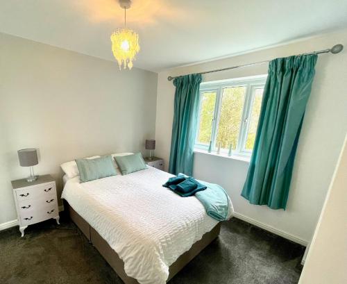 a bedroom with a bed and a window with green curtains at Otterhole Barn Holiday Apartment in Buxton