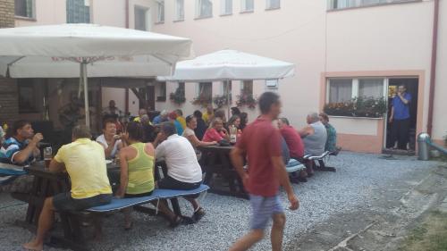 a group of people sitting at tables under umbrellas at Penzion Tomy Pihlov in Horní Planá