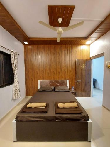 a bedroom with a bed with a ceiling fan at Vighnaharta Homestay in Ganpatipule