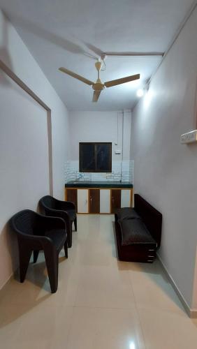 a living room with couches and a flat screen tv at Vighnaharta Homestay in Ganpatipule
