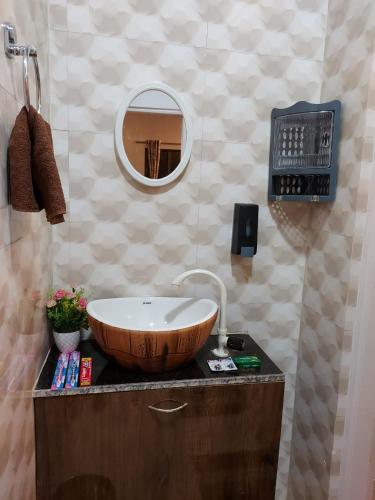 a bathroom with a wooden sink and a mirror at Vighnaharta Homestay in Ganpatipule