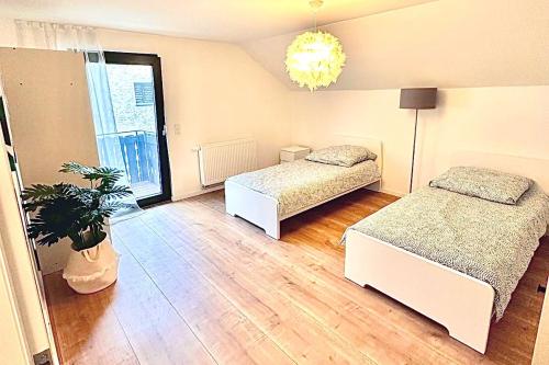 a bedroom with two beds and a potted plant at Beautiful House in Salzweg in Salzweg