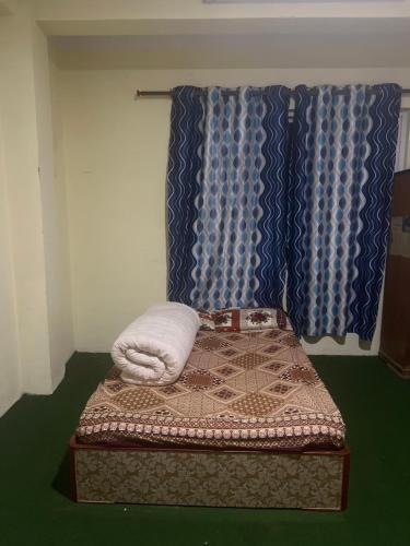 Khatri Niwas في Tokna: غرفة بسرير ومخدة وستائر