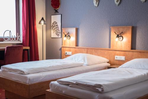 two beds in a hotel room with two lamps at Landgasthof Zum Goldenen Anker in Eggenstein-Leopoldshafen