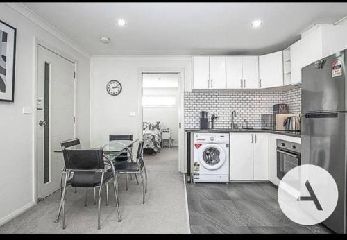a kitchen with a table and chairs and a refrigerator at Modern cottage central location in Phillip