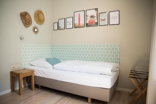 a bed in a room with pictures on the wall at Landgasthof Zum Goldenen Anker in Eggenstein-Leopoldshafen