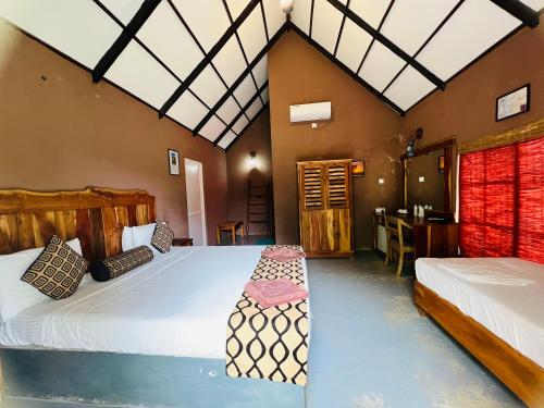 a bedroom with two beds and a table in it at Coco Village Hotel Chilaw in Chilaw