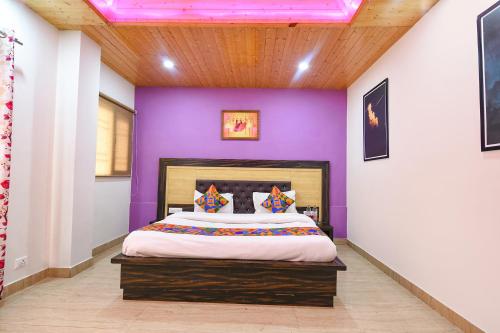 a bedroom with purple walls and a large bed at FabHotel The Kasauli Heavens in Kasauli