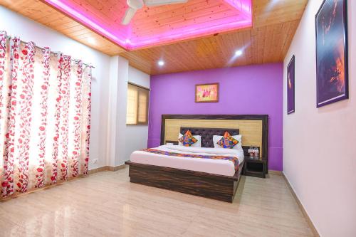 a bedroom with purple walls and a bed in a room at FabHotel The Kasauli Heavens in Kasauli